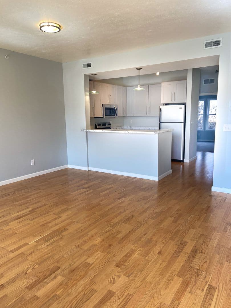 Open-concept living room with hardwood floors and kitchen breakfast bar