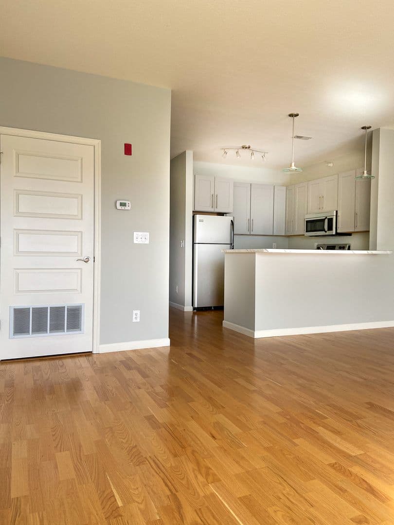 Living space with hardwood flooring looking toward the kitchen