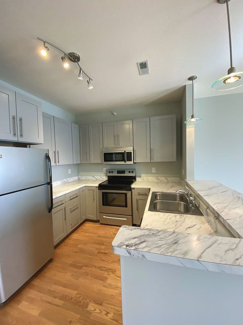 Kitchen with track lighting, breakfast bar, and stainless refrigerator