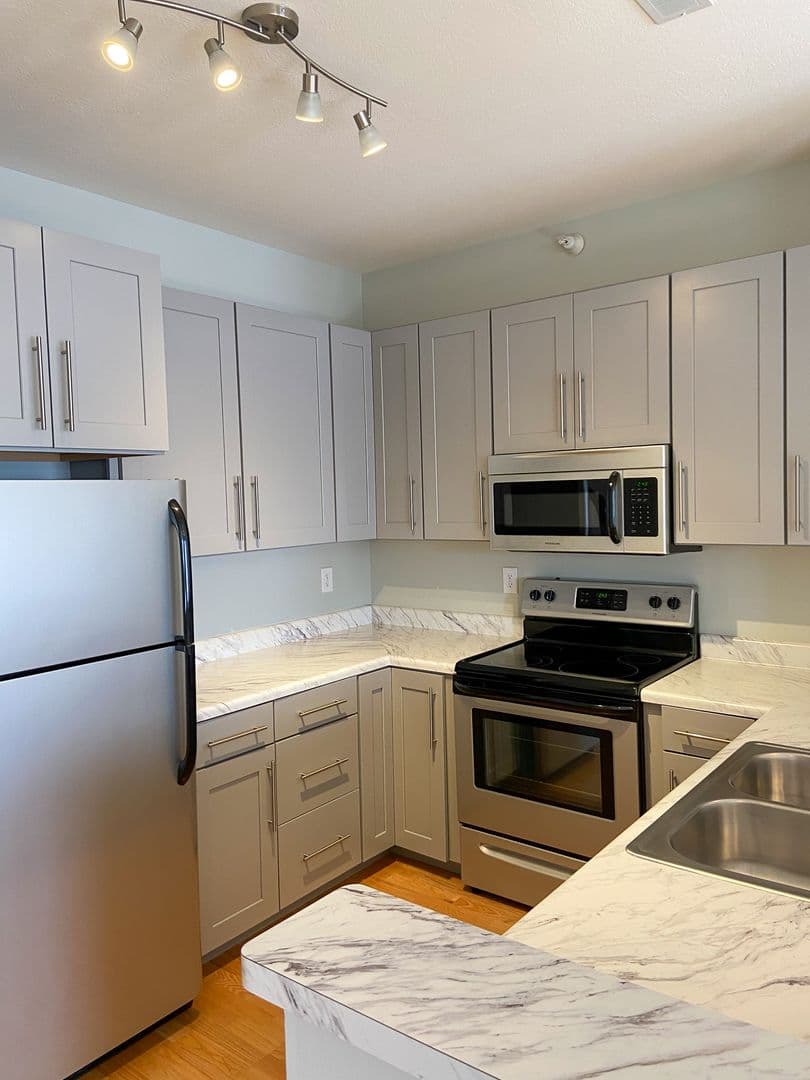 Kitchen with stainless steel range, microwave, and shaker cabinetry