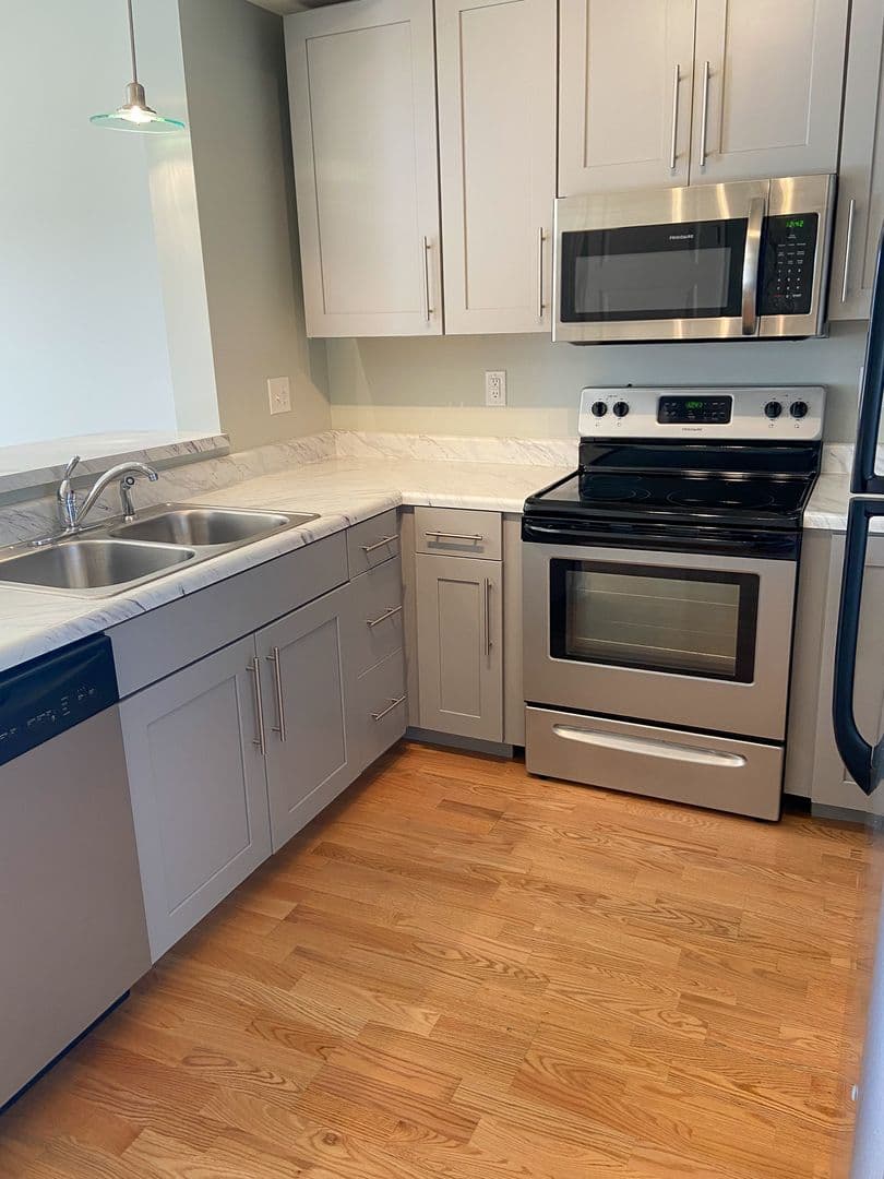 Kitchen with double-basin sink, dishwasher, and marble-style counters